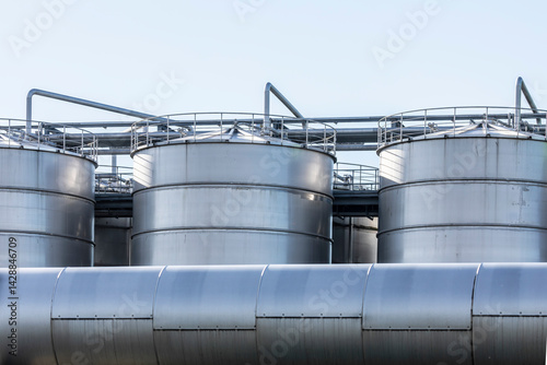 Industrielle Großbehälter in einem produzierenden Werk, die durch Rohrleitungen verbunden sind