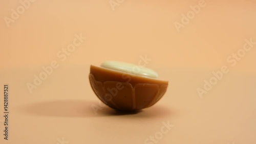White chocolate candy rotates on an orange background. White chocolate toffee on orange background.