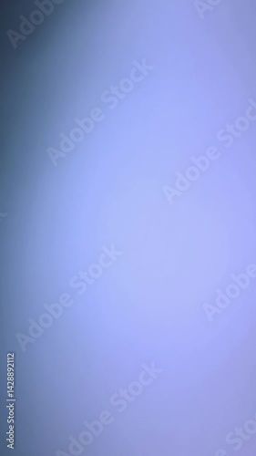 Soft gradient blue background with subtle lighting variations. The gentle illumination shifts slowly from lighter center to darker edges, creating a calm atmospheric backdrop perfect for copy space.