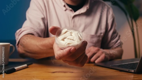 Snus nicotine tobacco close up, pack of tobacco for gum. unhealthy addiction. Man opening box with snus and taking one. 