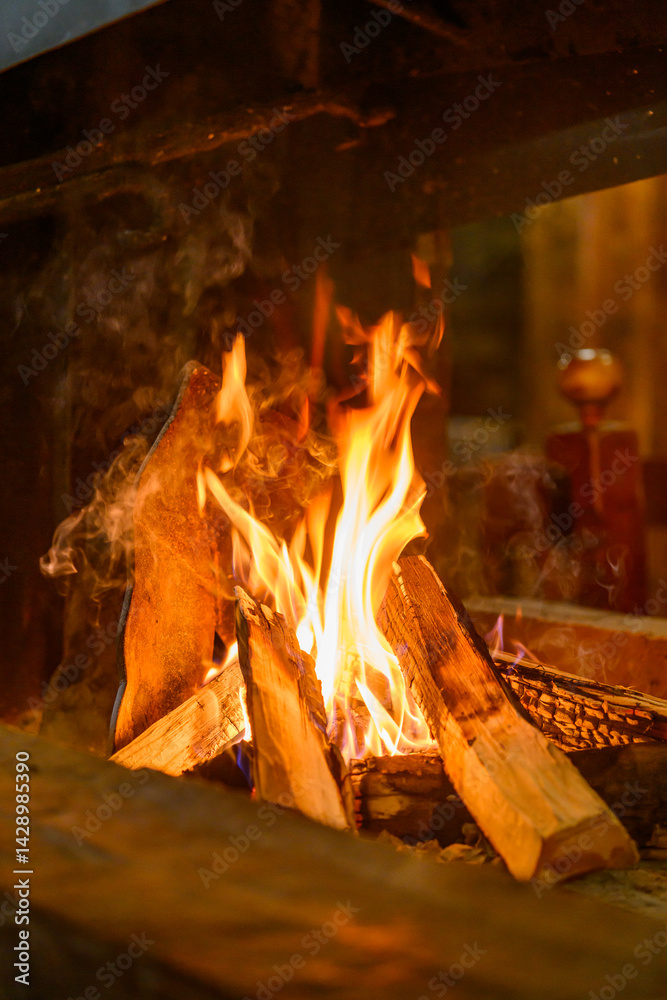 Log fire and firewood in the fireplace for a cozy winter atmosphere