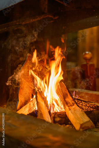 Obraz na płótnie Log fire and firewood in the fireplace for a cozy winter atmosphere w salonie