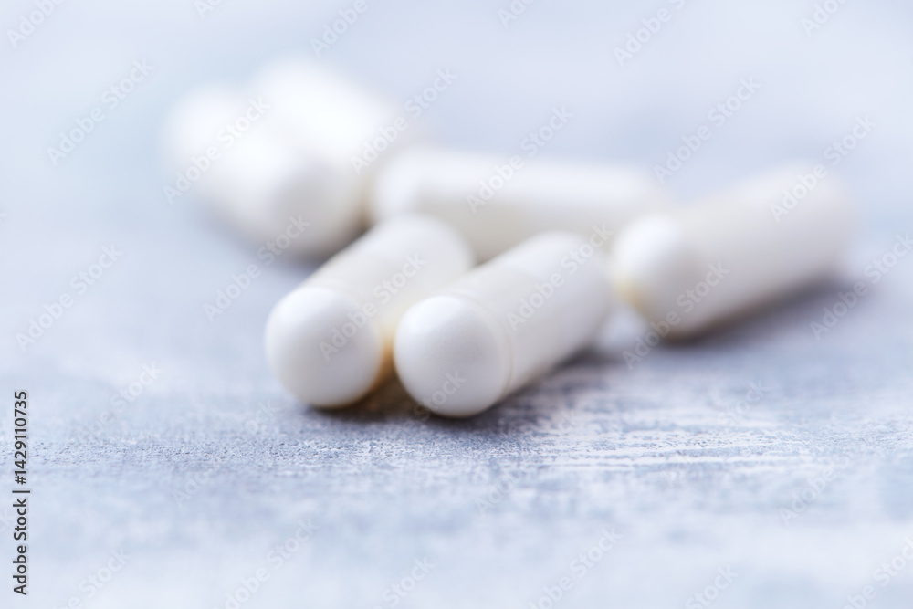 Creatine capsules on bright wooden background. Soft focus. Close up. Copy space. Creatine capsules on bright wooden background. Soft focus. Close up. Copy space.