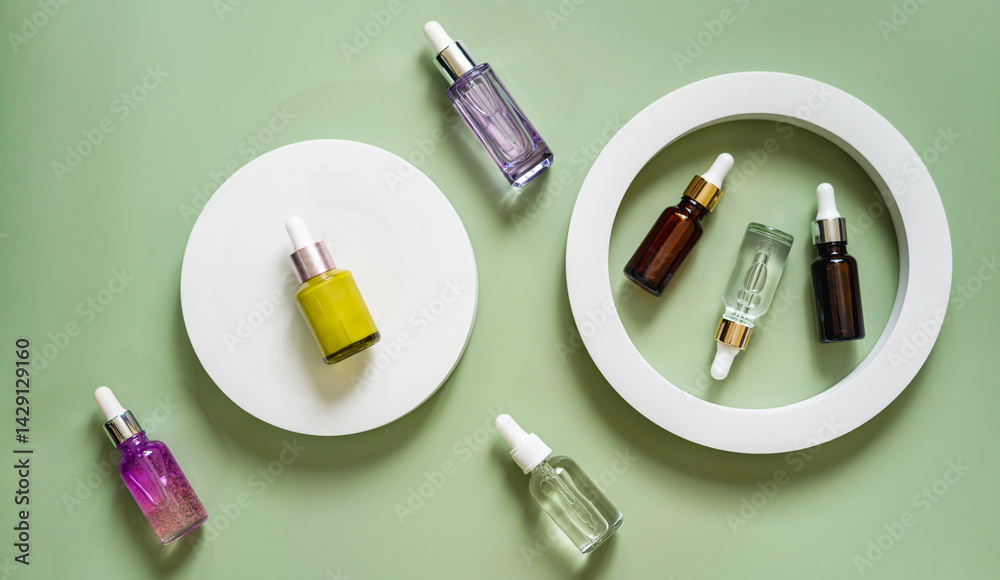 Different glass bottles with serum or oil on green background. Trending shadow. Cosmetic mockup. Top view with copy space. Flat lay.