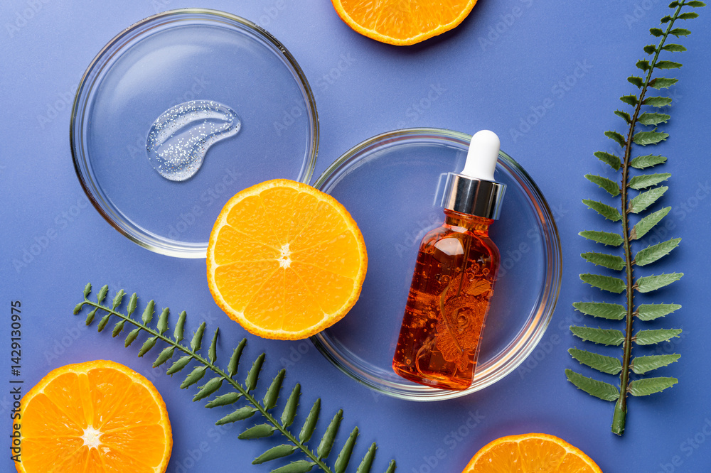 Citrus fruit vitamin c serum oil beauty care, anti aging natural cosmetic with fresh orange fruits on blue background, top view