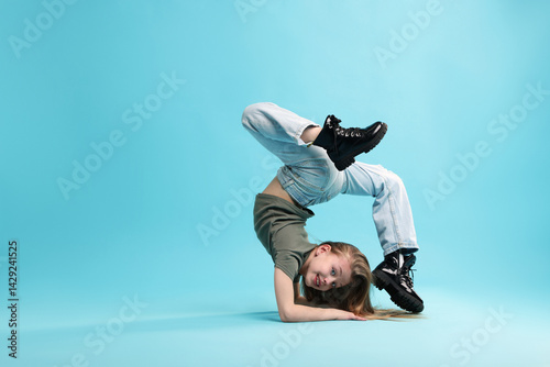 Obraz na płótnie Girl in stylish clothes dancing on light blue background, space for text w salonie
