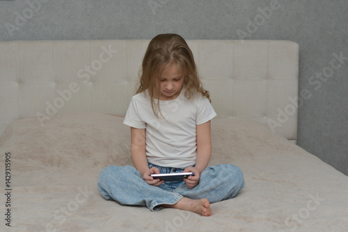 Focused Young Girl Using Smartphone on Bed