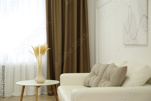 Obraz na płótnie Sofa and window with brown curtains in simple room interior w salonie