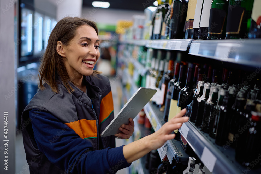 Happy supermarket employee using touchpad while checking stock of supplies on shelves. Happy supermarket employee using touchpad while checking stock of supplies on shelves.