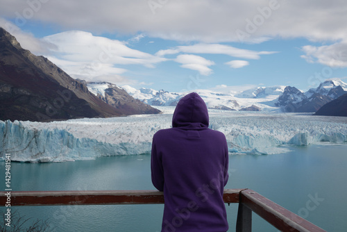 Obraz na płótnie Female adventurer watches as glacier breaks from mountain due to global warming at Perito Moreno glacier, Patagonia, Argentina. w salonie