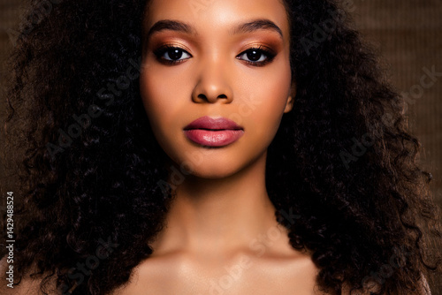 Portrait of a stunning young woman with professional makeup and curly hair, showcasing elegance and confidence