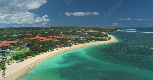 Obraz na płótnie Capturing stunning aerial views of Nusa Dua beach in Bali, showcasing white sand, luxury hotels, lush greenery, and vibrant turquoise waters under a clear sky w salonie