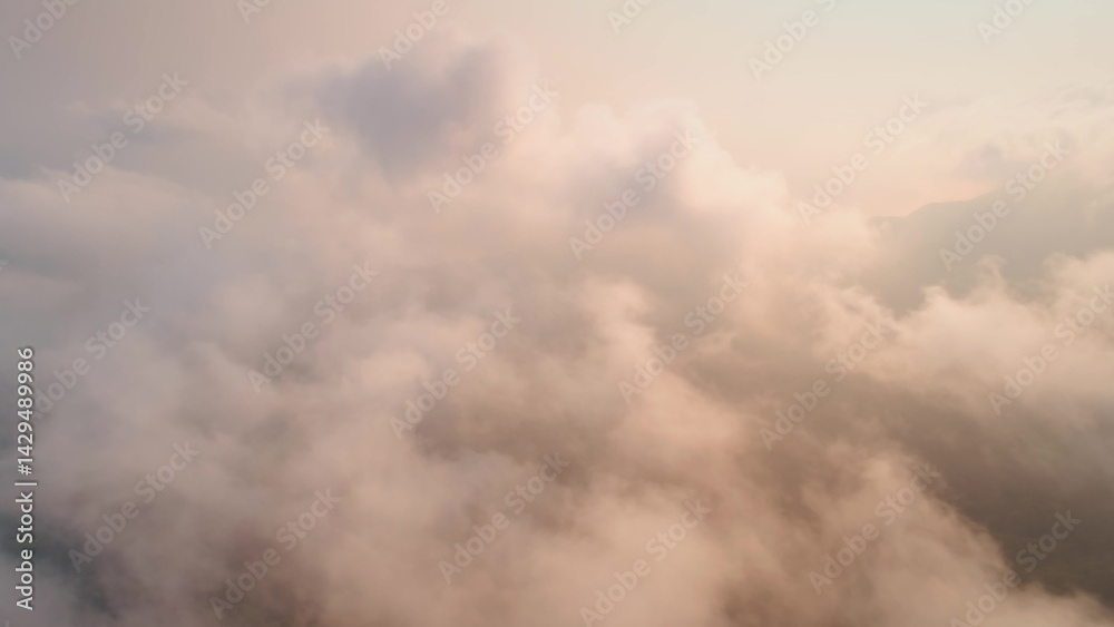 Capturing a breathtaking aerial view of fluffy cloudscapes during sunset, creating a serene atmosphere filled with warm pastel colors that evoke tranquility and beauty