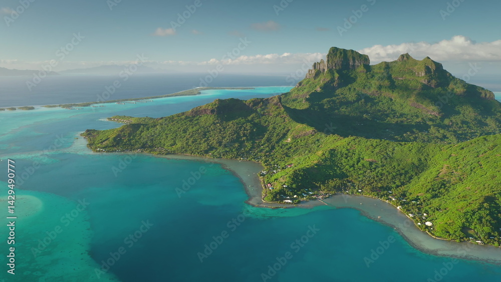 Aerial drone flight over breathtaking beauty of Bora Bora, French Polynesia, mount Otemanu, lush greenery, and vibrant turquoise lagoon. Wild travel destination, remote exotic summer nature paradise