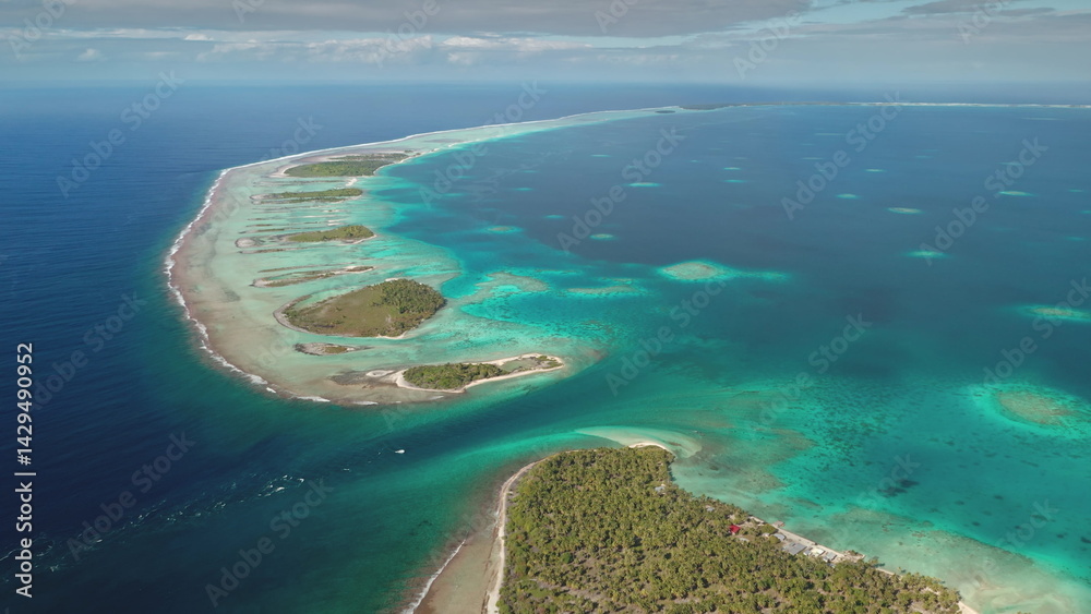 Stunning aerial perspective showcases a series of small tropical islands surrounded by vibrant turquoise waters. The scene reflects the beauty of unspoiled nature along the coastline during daylight.