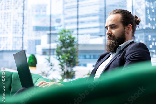 Powerful CEO in a corporate headquarters plans company expansion, balancing profit reports and evaluating market trends on his laptop. Making data driven decisions for enterprise success.