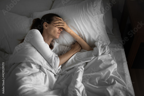sad depressed tired woman home alone in her bed getting bad sleep  