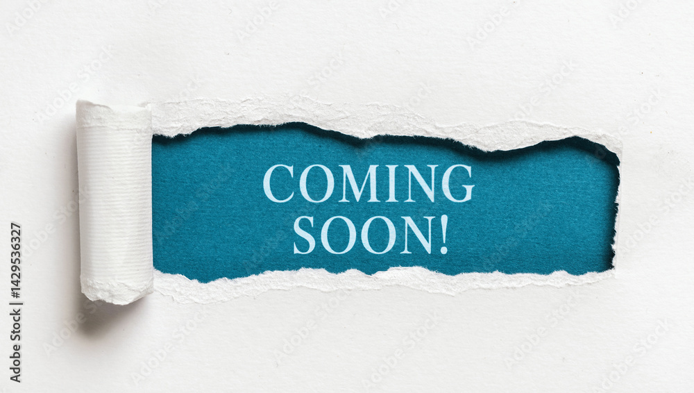 Text coming soon written on blue background behind ripped white paper creative announcement concept for marketing promotions and launch campaigns