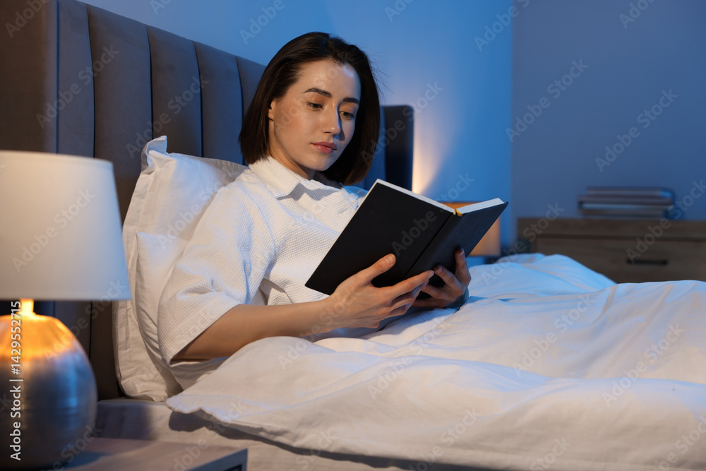 Young woman reading book in bed at home Young woman reading book in bed at home