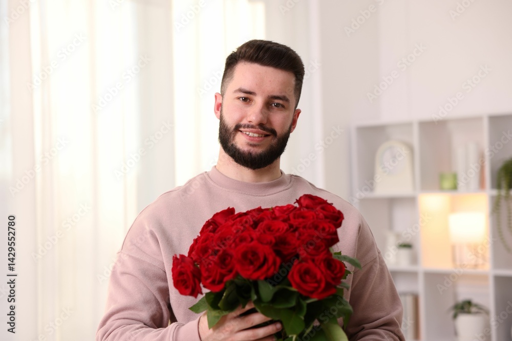 Man with bouquet of red roses at home Man with bouquet of red roses at home