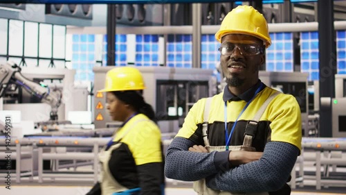 Wallpaper Mural Portrait of technician overseeing solar panel production lines equipment. African American man maintaining photovoltaic assembly systems in automated industry 4.0 factory using computer, camera A Torontodigital.ca
