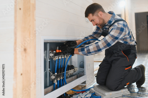 Master installs the overlapping thermal insulation in the room. Floor heating installation. Repair in the apartment, floor insulation photo