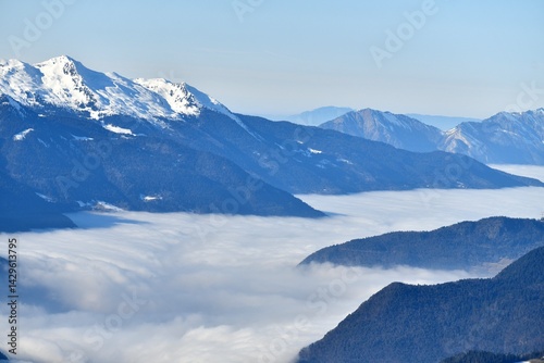 Winter scenery of French alps with tones of blue under clouds and snow
