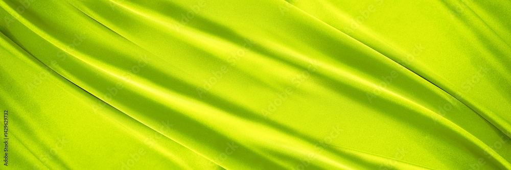 Yellow green silk satin. Lime color shiny silky smooth fabric. Soft wavy fold lines. Elegant background. Curtain drapary. Design. Bright. Light. Wide banner. Panoramic. Template.