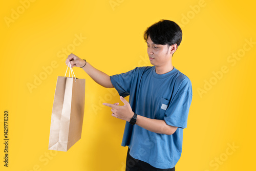 a man with brown shopping bag and pointing to it