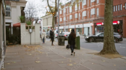 Wallpaper Mural Defocused scene of people walking on a london street in autumn with blurred buildings and traffic, showcasing urban life in the uk with a man and woman in the foreground. Torontodigital.ca