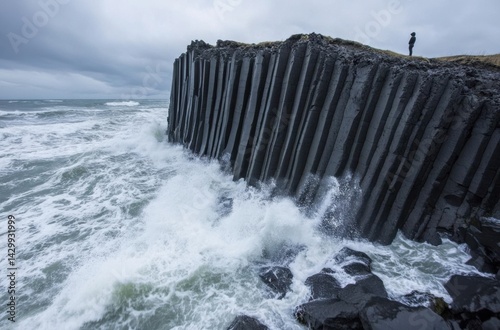 A lone traveler standing on a basalt column beach
