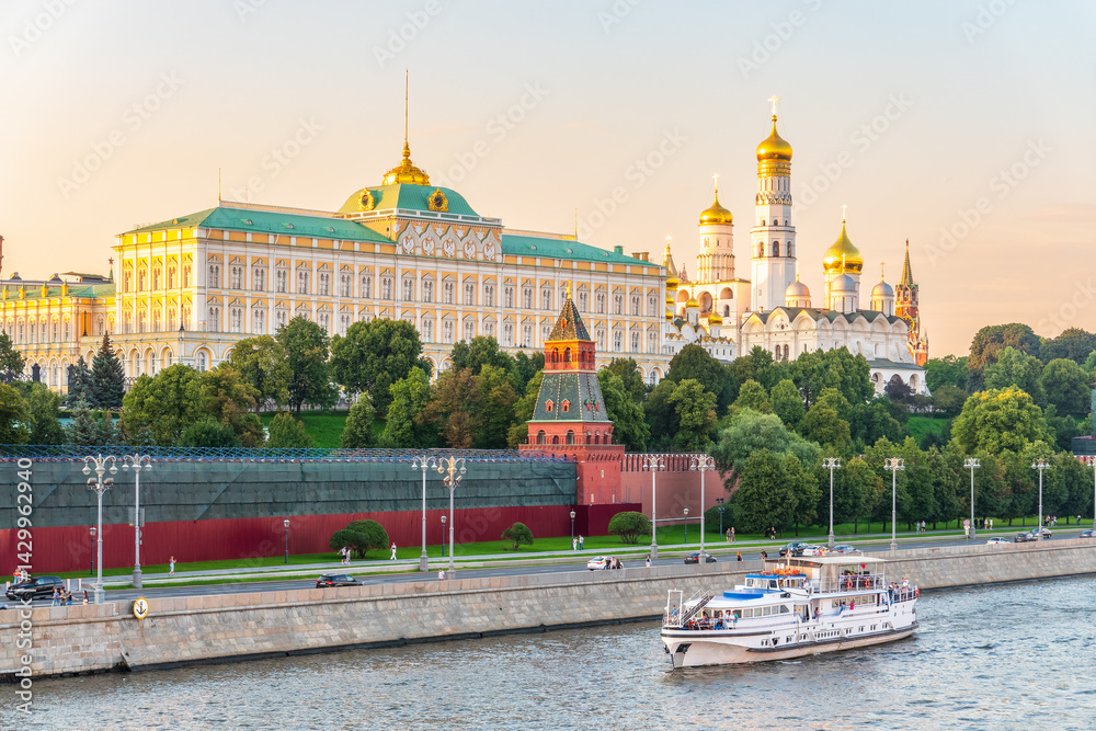 View of Kremlin with Vodovzvodnaya tower, Grand Kremlin Palace from repaired Bolshoy Kamenny Bridge in Moscow city on sunny summer day. Cruise ship sails on the Moscow river View of Kremlin with Vodovzvodnaya tower, Grand Kremlin Palace from repaired Bolshoy Kamenny Bridge in Moscow city on sunny summer day. Cruise ship sails on the Moscow river
