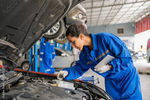 Female Auto mechanic are checking and repair maintenance auto engine.