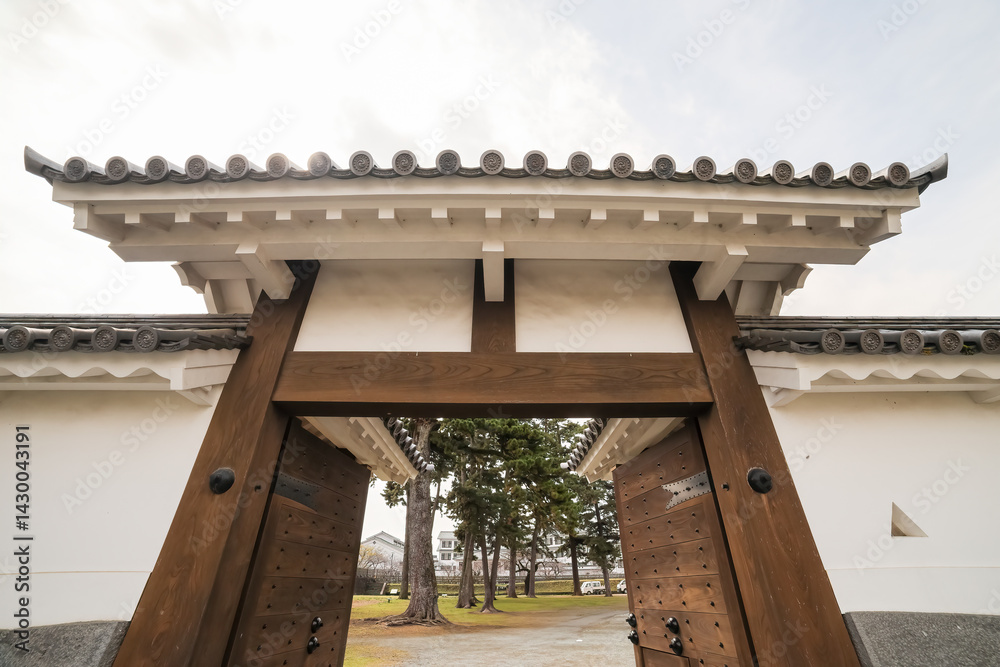 Fototapeta premium 立派な城門。 石垣や銅板で補強されていて非常に堅固。 屋根には鯱等も載っている。 日本の関東地方最大級の城、小田原城。 戦国時代（15〜16世紀）に関東一円を支配した北条氏の居城。 現代では公営の城址公園として整備されている。 本丸内資料館等、一部の有料施設以外のすべての公園部分は２４時間無料で市民に公開されている。 小田原城址公園、小田原市、神奈川県-2025年3月30日 