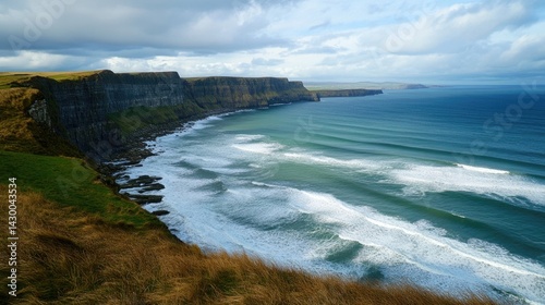 A wide view of a serene Irish coastline, with rolling waves and clusters of seafoam-covered rocks.