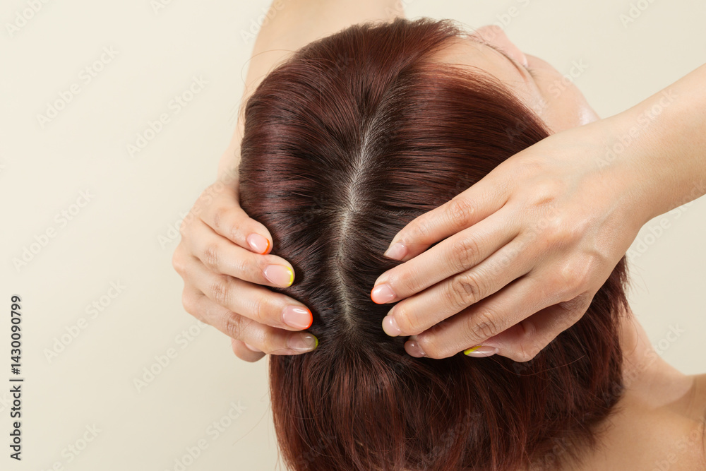 Naklejka premium 若いアジア人の女性は頭皮をマッサージしています。
