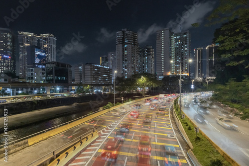 Fototapeta Naklejka Na Ścianę i Meble -  Car rushing by on the busy urban road in the city center of Kuala Lumpur at night