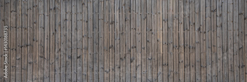 wooden long vertical wall facade fence made of planks line wood brown background in web panoramic header large panorama