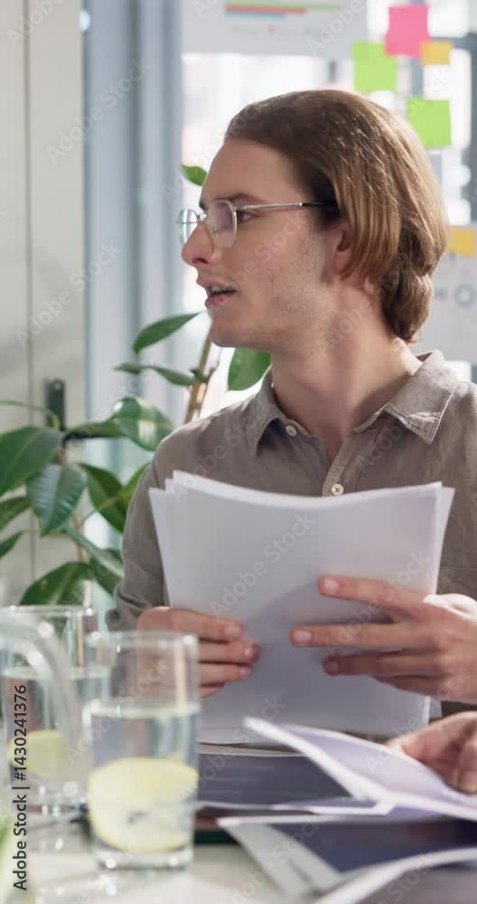 Man, paperwork and report for meeting at startup, review and planning for proposal at tech company. Person, documents and check stats with talking, insight and project management in office at agency Man, paperwork and report for meeting at startup, review and planning for proposal at tech company. Person, documents and check stats with talking, insight and project management in office at agency