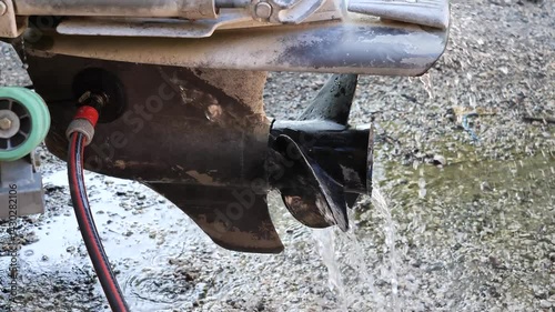 A boat's propeller is controlled with water. The water escapes from the propeller and splashes onto the ground.