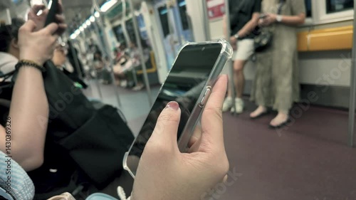 Close-up view of smartphone on hands of female in subway passenger and Watching Video, Scrolls Through News, or searches for information on the Internet.