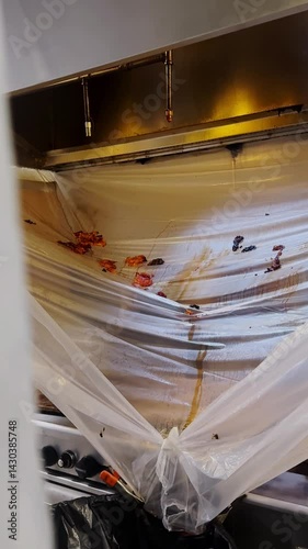 Video of a professional team's setup of a plastic cleaning commercial kitchen hood in the kitchen.