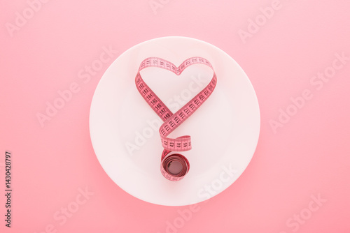 Behang Heart shape created from measure tape on white plate on light pink table background