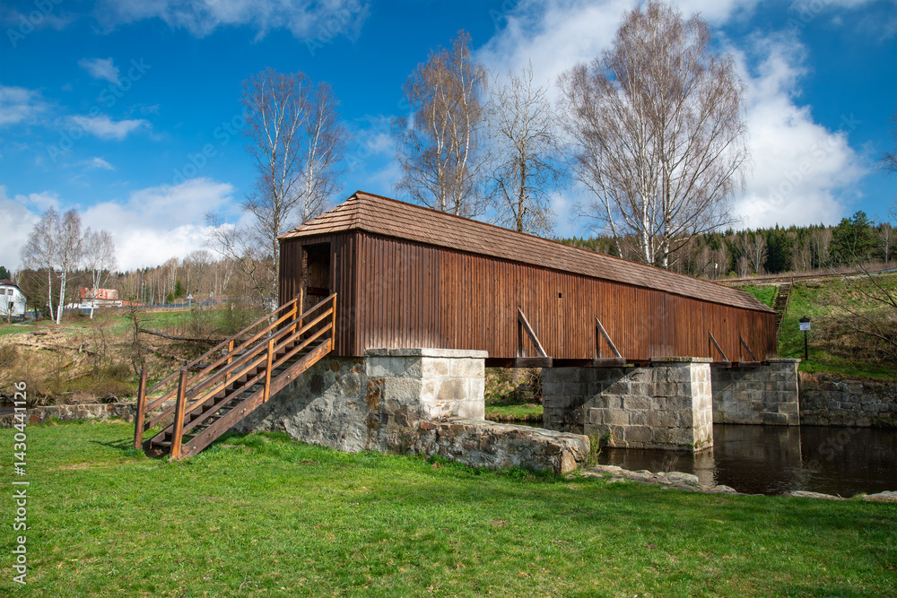 The picturesque covered wooden bridge Rechle near Lenora in the Šumava mountains – a unique national cultural monument - historic bridge with a wooden deck and stone pillars
