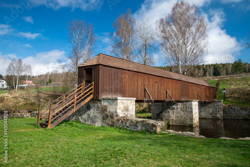 Obraz na płótnie The picturesque covered wooden bridge Rechle near Lenora in the Šumava mountains – a unique national cultural monument - historic bridge with a wooden deck and stone pillars w salonie