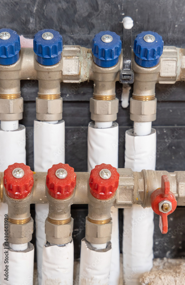 Pipes and valves for hot and cold water in heating and water supply system in boiler room closeup