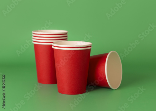 Obraz na płótnie Disposable red paper cups on a green closeup, mockup. No plastic and sustainable Christmas w salonie