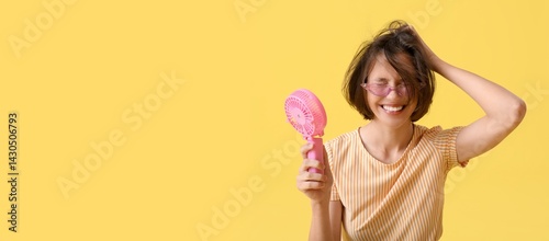 Young woman with mini fan o...