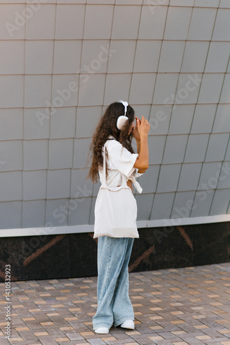 Girl With Stylish Headphones Against Wall