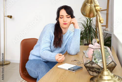 Sad young woman counting mo...
